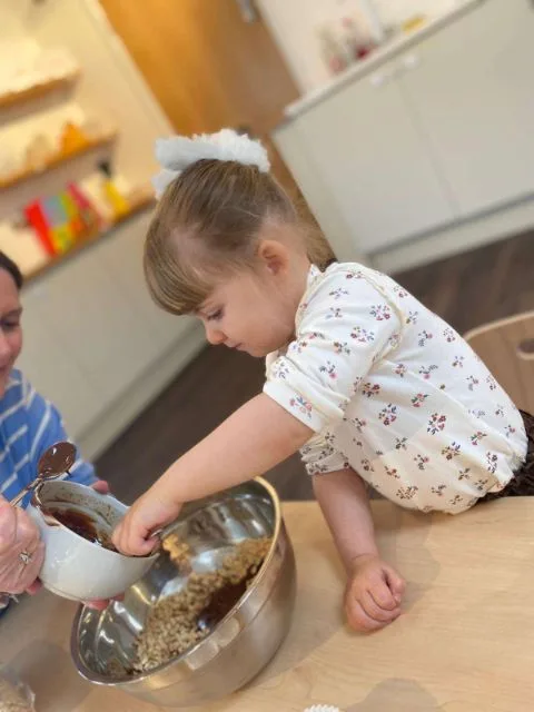 A young child baking and mixing ingredients in a bowl