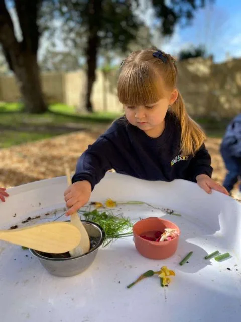 A nursery child taking part in a hands-on table activity