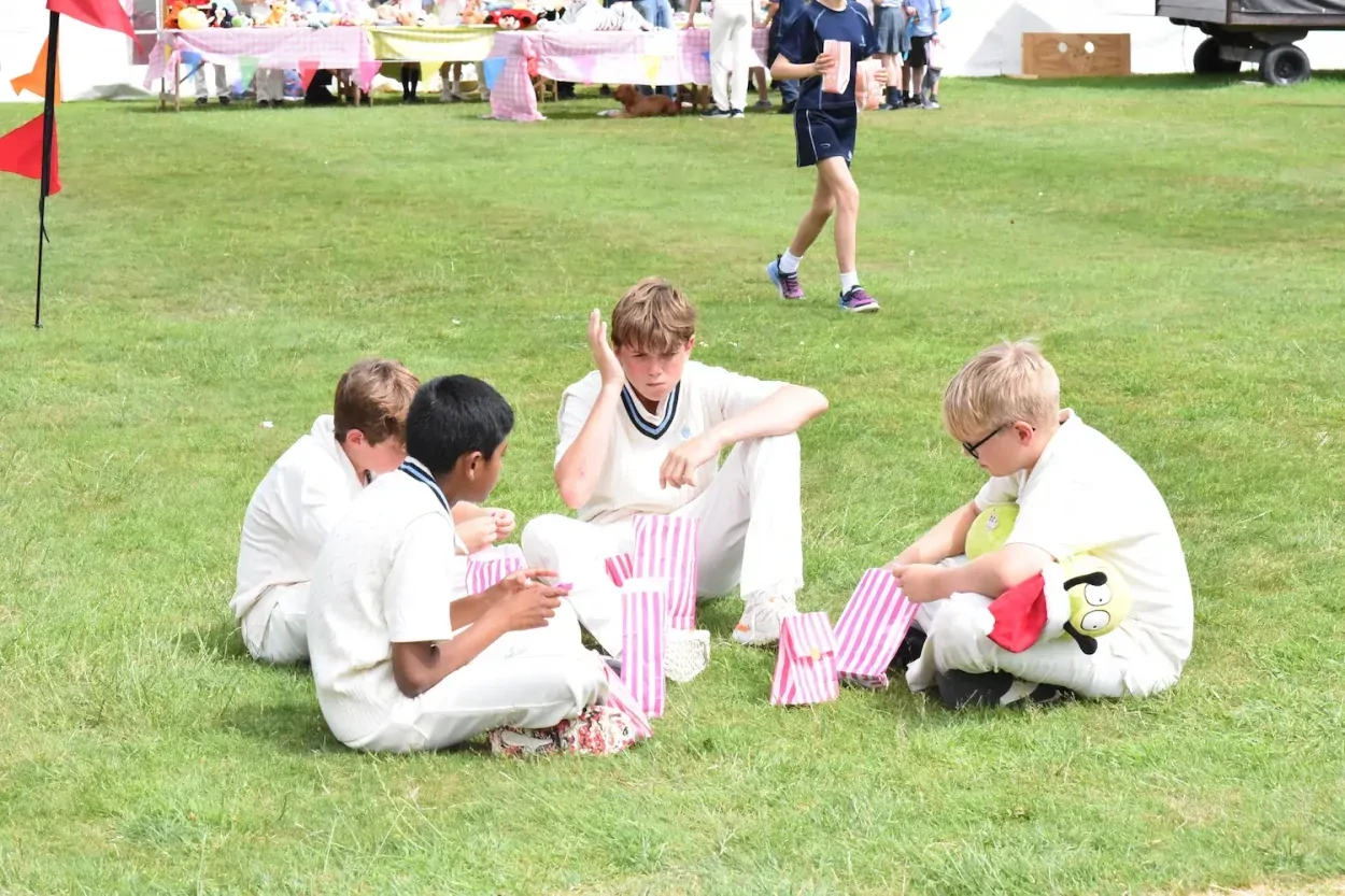 School pupils eating sweets on the grass