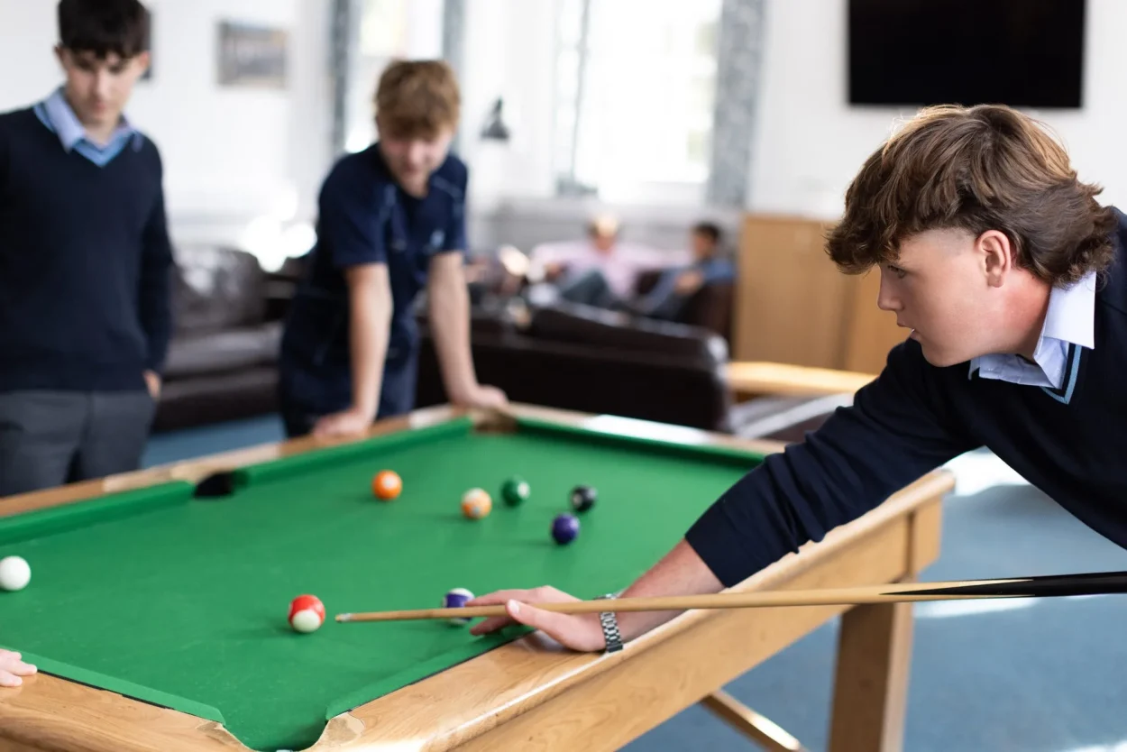 Pupils playing pool in the house