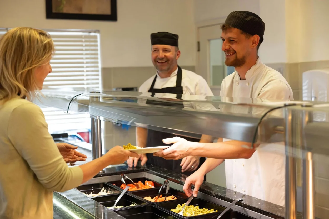 Catering staff serving a member of staff