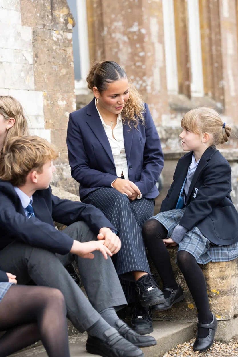 A sixth former chatting with younger pupils