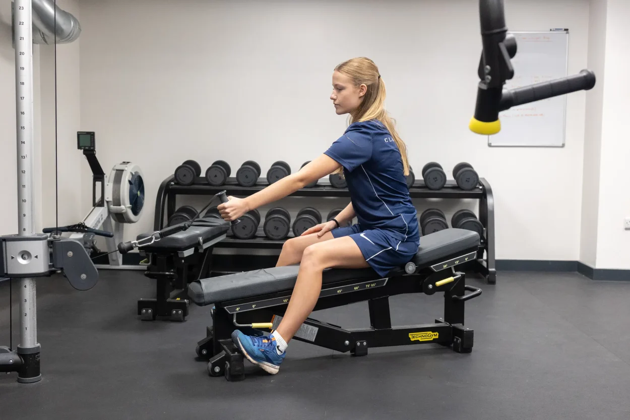 female pupil in the gym rowing