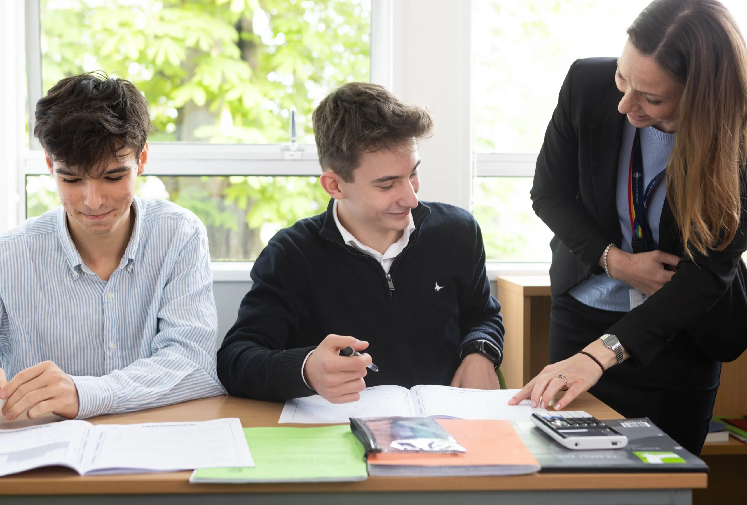 Senior pupils working with their teacher in a classroom