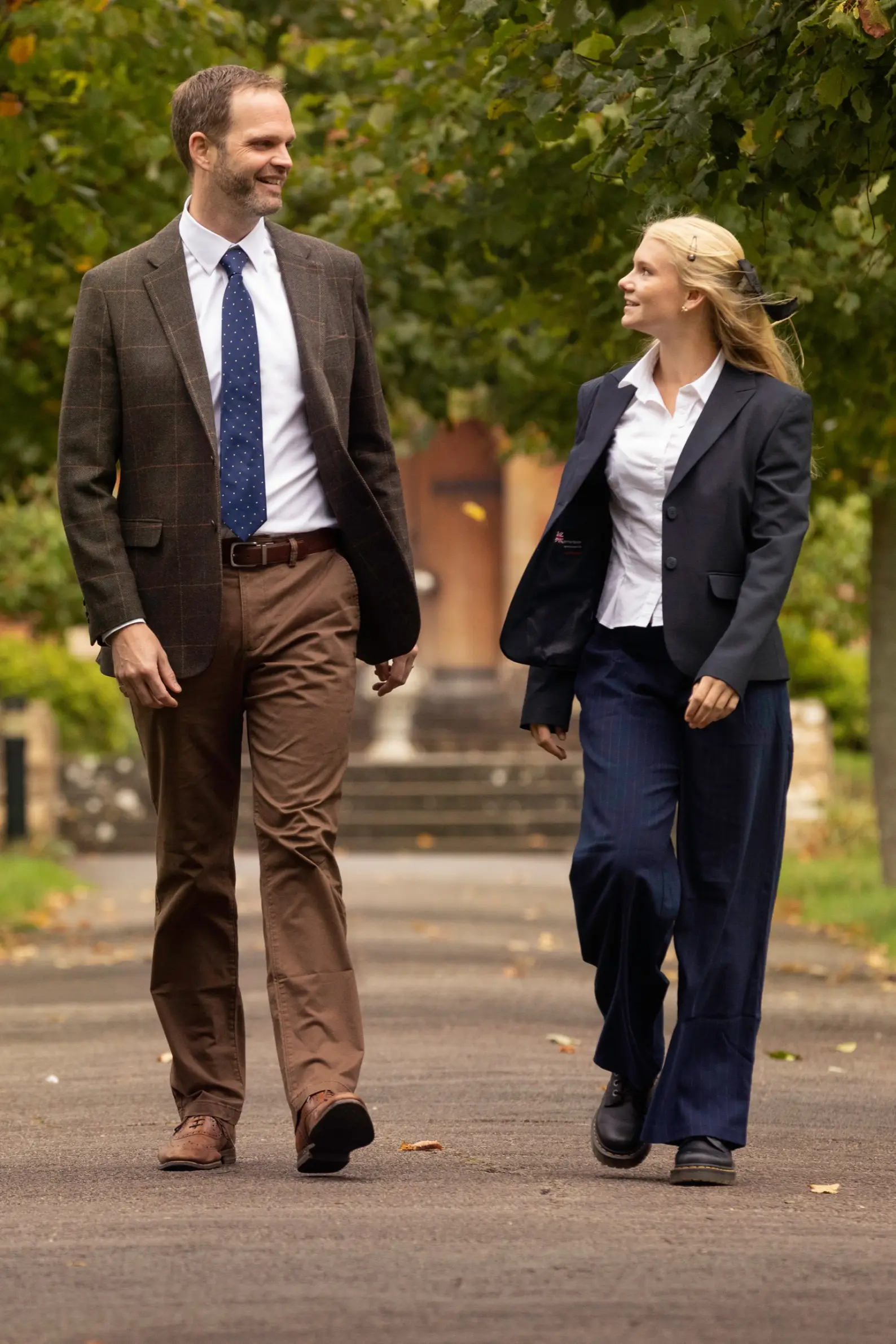 Sixth Form student walking and talking with a member of staff